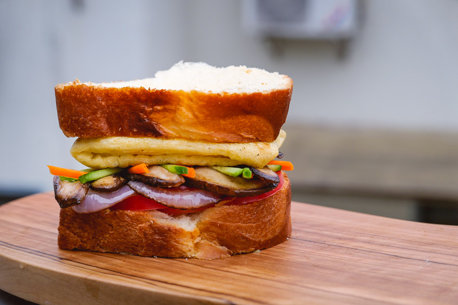 Fully loaded plant-based sandwich for vegans. Easy recipes with plant-based egg alternative JUST Egg. Photos by Rachel Gouk @ Nomfluence.