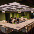 Interiors of Bar Opia show a grid-like light panel over the square-shaped sunken bar, the bar station in the center